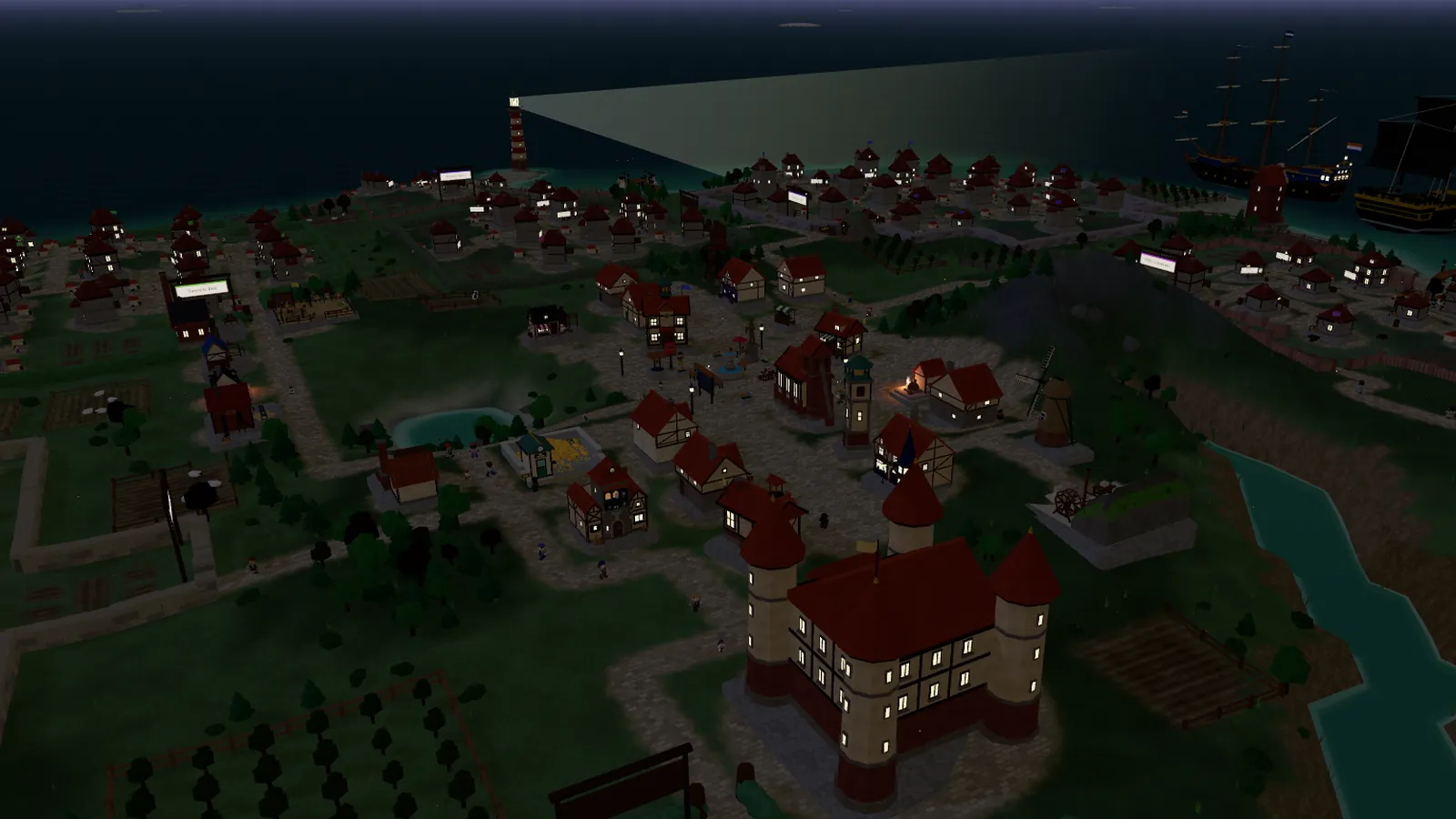 The same view at nine in the evening: lit windows, lamps on the square and the lighthouse beam over the sea.